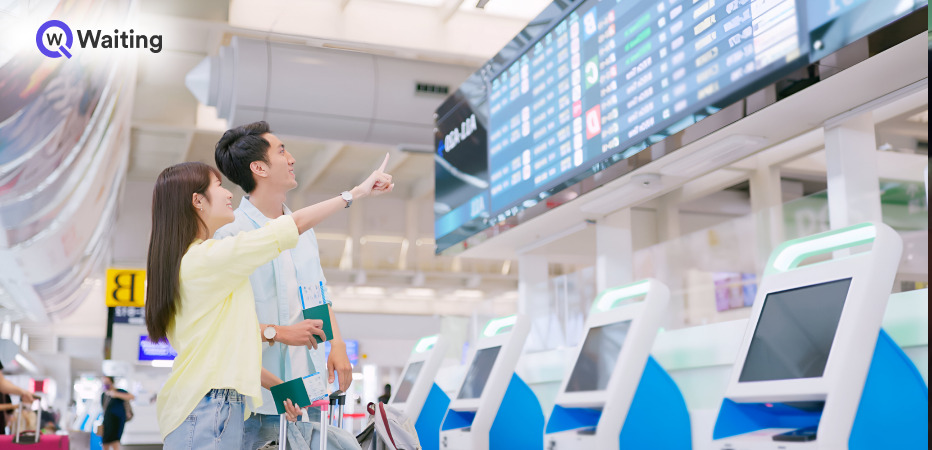 Travelers checking flight info at airport near self-check-in kiosks, showing airport queue management. 